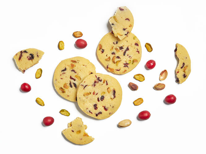 Pistachio & Cranberry Shortbreads surrounded by pistachios and cranberries.